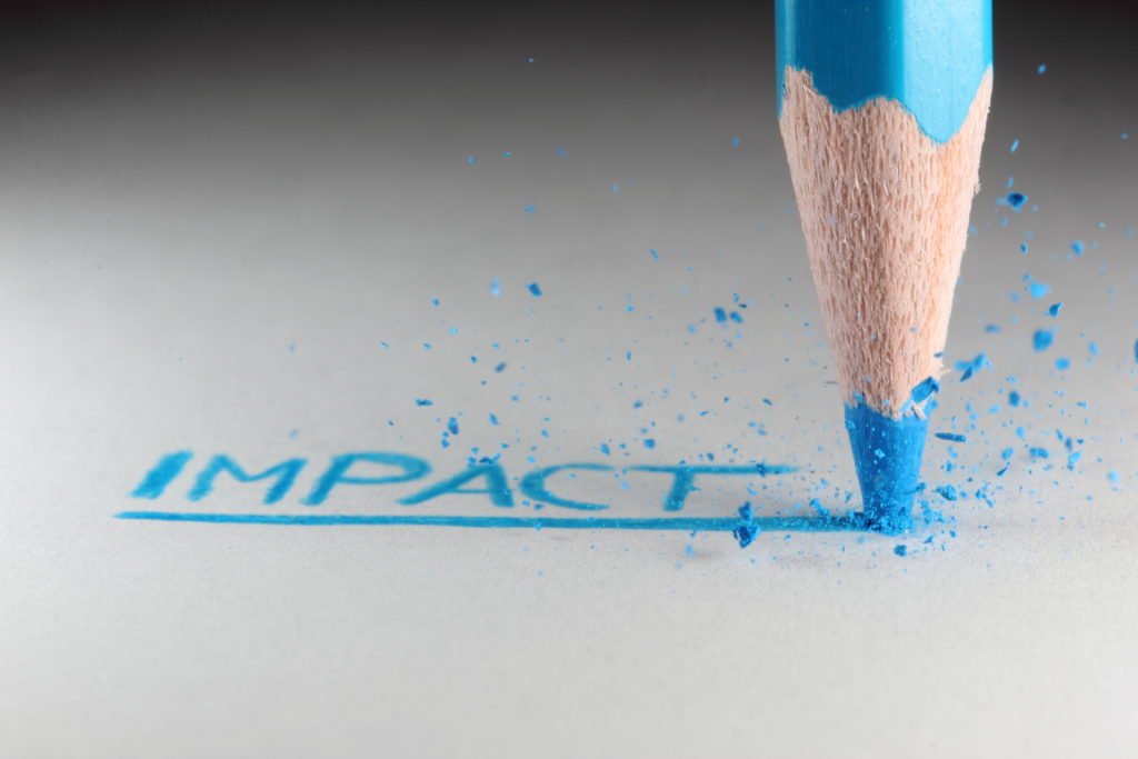 The word Impact written by a blue pencil