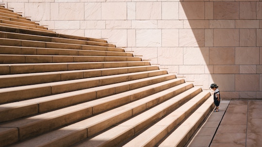 Image of a toddler facing a giant staircase